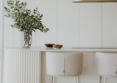 Stunning kitchen island styled with ornamental foliage in a decorative vase