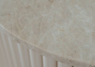 Close-up of the curved end of a kitchen island featuring Taj Mahal stone