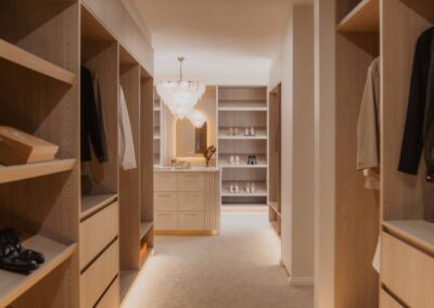Two colorful occasional chairs bring personality and charm to the master bedroom, positioned in front of sheer curtains that softly diffuse natural light and enhance the room’s serene ambiance.