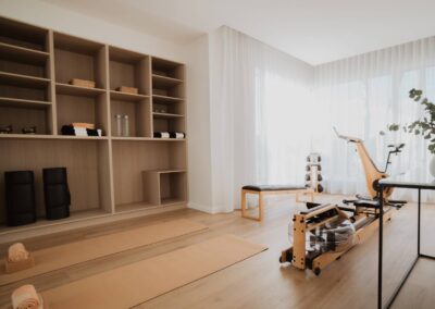 Soft and elegant home gym featuring yoga mats and stylish timber fitness equipment