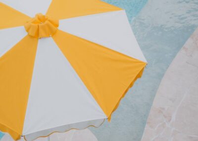 Yellow and white retro umbrella mounted on a pontoon in a modern pool