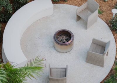 Modern firepit positioned near the pool, surrounded by elegant outdoor seating