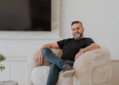 Designer seated in a fluffy swivel armchair within a bright, modern lounge