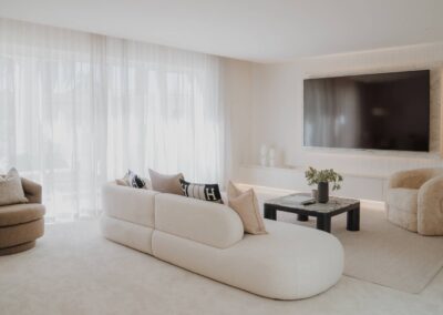 Curvy luxury sofa set against sheer closed curtains in a modern lounge room