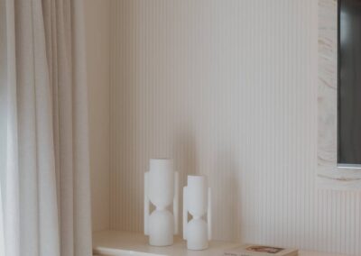Scalloped wall feature with decorative vases and soft sheer curtain in a modern interior